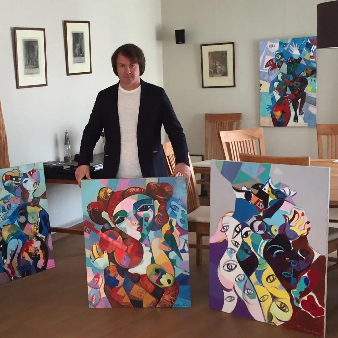 Igor Tcholaria with his paintings at an exhibition